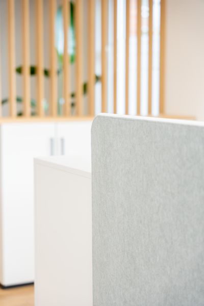 Eine maßgefertigte Lamellenstruktur aus hellem Holz zoniert den Raum