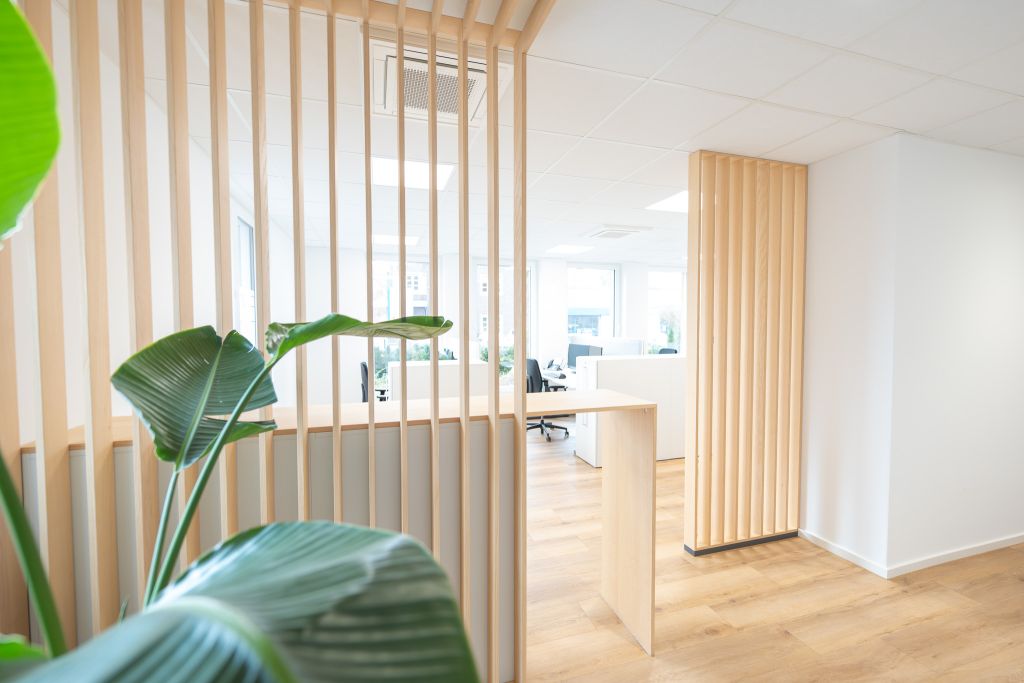 Eine maßgefertigte Lamellenstruktur aus hellem Holz zoniert die Räume