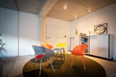 Empfangslösung mit bunten Armlehnstühlen, Beistelltisch und Stauraummöglichkeit