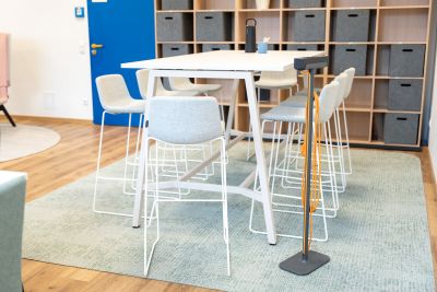 Hochtisch-Settings und flexible Sitzmöglichkeiten unterstützen spontane Gespräche und gemeinsames Miteinander